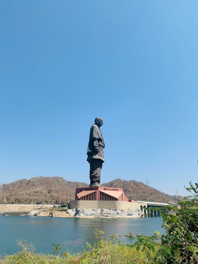 man in black jacket statue near body of water during daytime